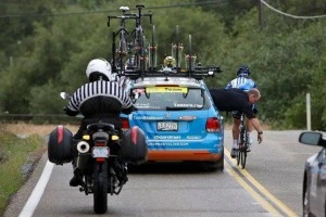 John leans out the support vehicle to offer a quick repair in motion!